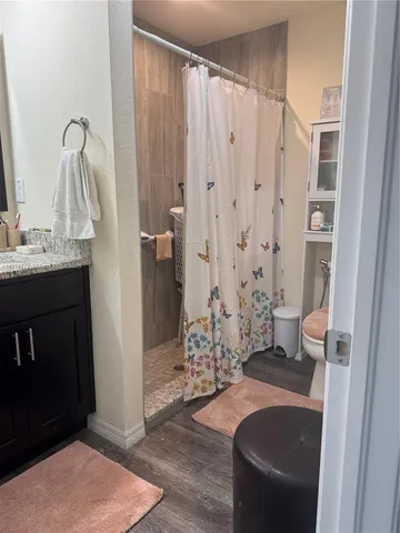 a bathroom with a granite countertop sink a toilet and shower