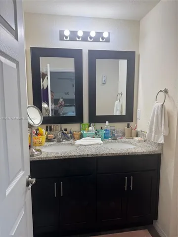 a bathroom with double sink and a mirror