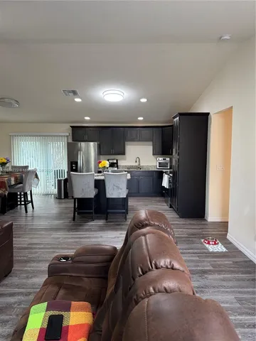 a living room with furniture and kitchen view