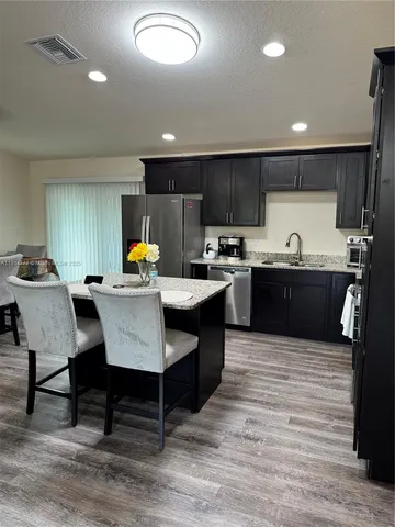 a large kitchen with a table and chairs