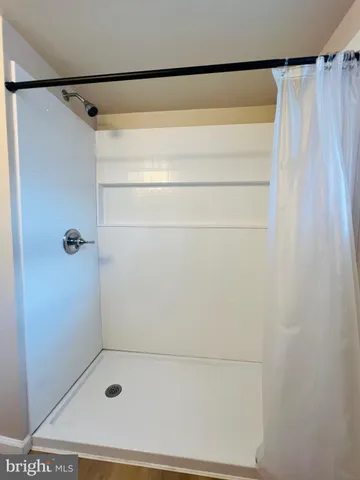 a bathroom with a shower and a glass door