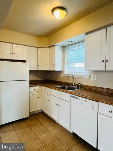 a kitchen with granite countertop white cabinets and white appliances
