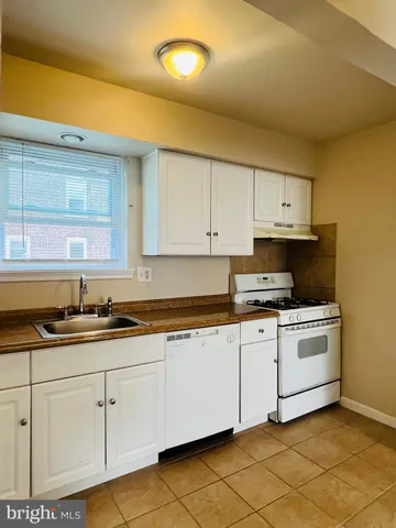 a kitchen with granite countertop white cabinets and white appliances