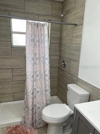 a white toilet sitting next to a shower curtain