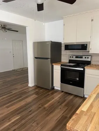 a kitchen with a refrigerator and a stove top oven