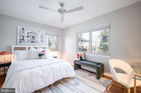a bedroom with a bed and a chair with the bookshelf