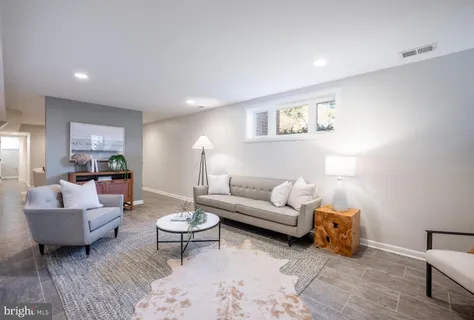 a living room with furniture and view of kitchen