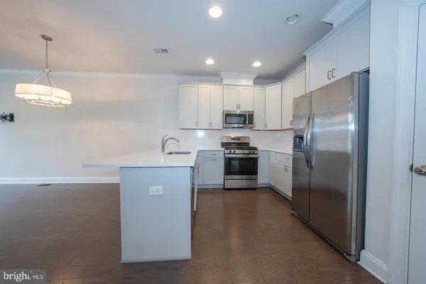 a kitchen with appliances a sink and cabinets