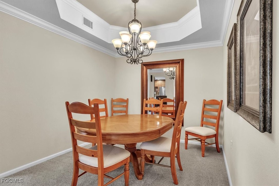 3110 Meandering Way, Unit 101 Fort Myers, FL 33905 - Photo 19 of 50 a dining room with furniture a chandelier and a window