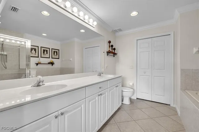 a spacious bathroom with a double vanity sink a mirror and a bathtub