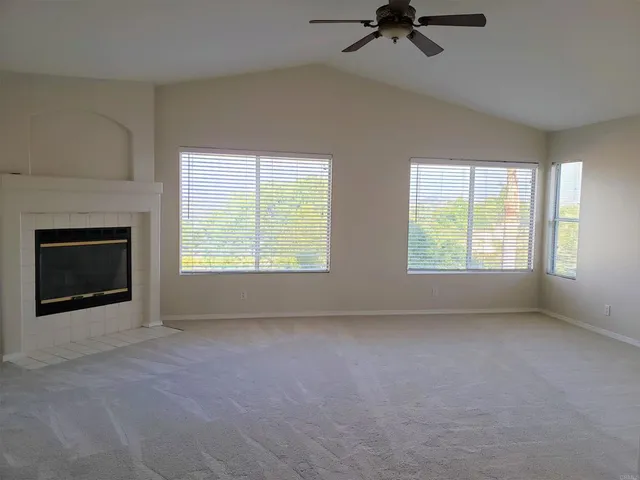 an empty room with windows and fireplace
