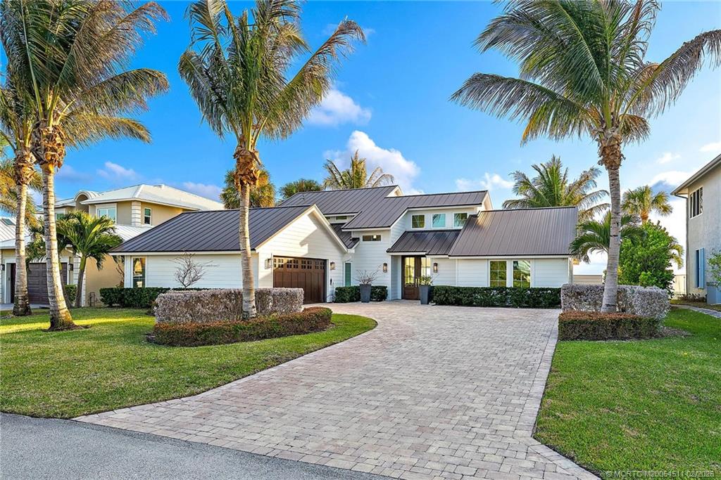 4230 Northeast Joes Point Road Jensen Beach, FL 34957 - Photo 13 of 62 a front view of a house with a garden and trees