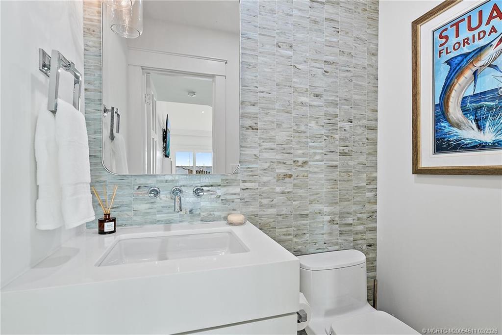 4230 Northeast Joes Point Road Jensen Beach, FL 34957 - Photo 31 of 62 a bathroom with a toilet sink and mirror