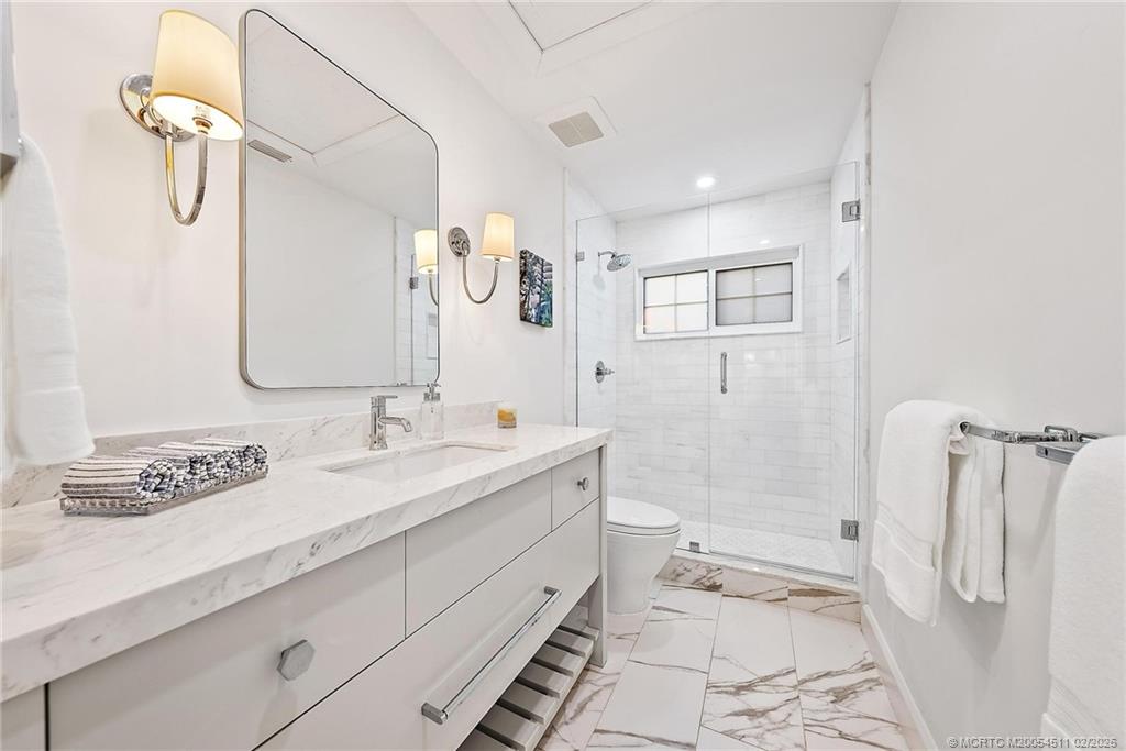 4230 Northeast Joes Point Road Jensen Beach, FL 34957 - Photo 33 of 62 a bathroom with a double vanity sink mirror double and shower