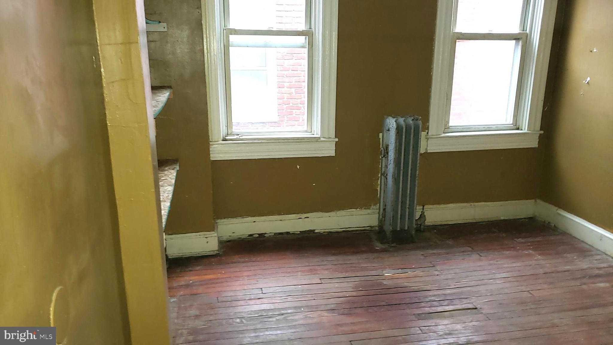 2215 Mt Holly Street Baltimore, MD 21216 - Photo 6 of 12 an empty room with wooden floor and a window