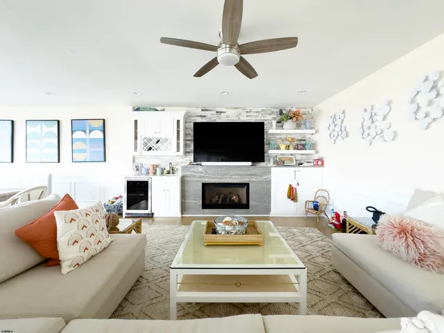 a living room with furniture a flat screen tv and a fireplace