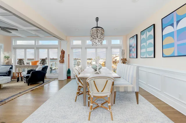 a view of a dining room with furniture a chandelier and wooden floor