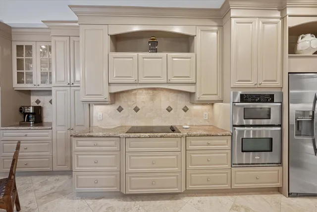a kitchen with granite countertop white cabinets and stainless steel appliances