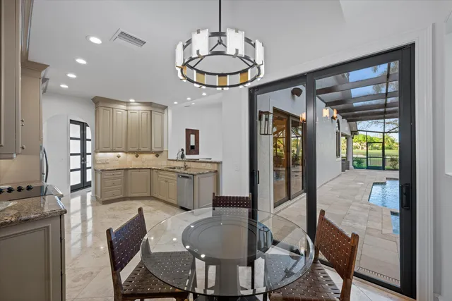 a dining room with furniture a kitchen view and a chandelier