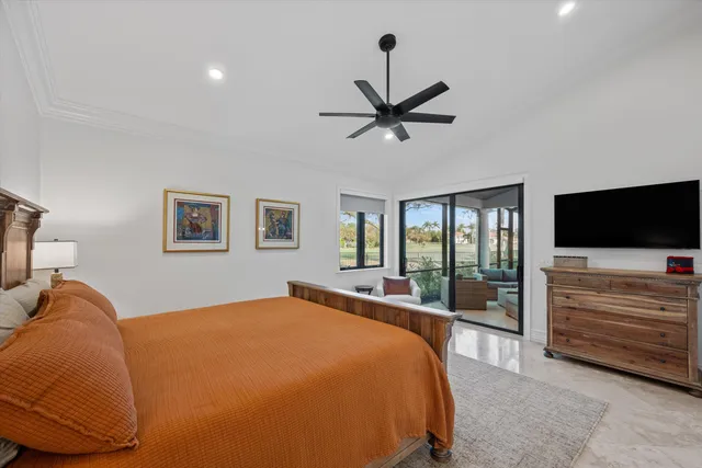 a bedroom with a bed and a flat tv screen on the dresser