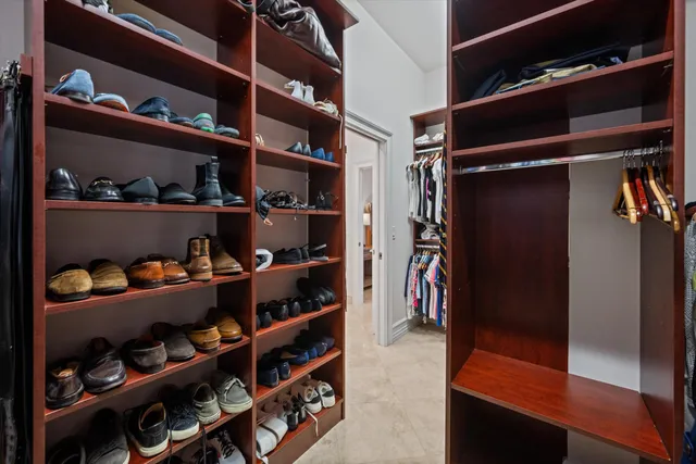 a view of walk in closet with clothes and shoes