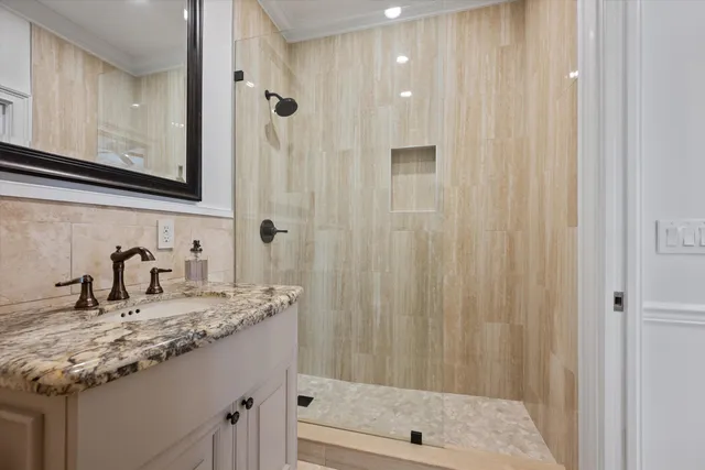 a bathroom with a granite countertop sink and a mirror