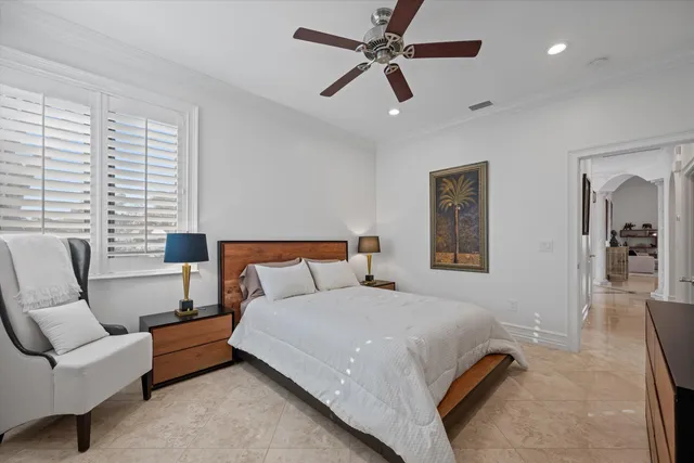 a spacious bedroom with a bed a couch and a ceiling fan