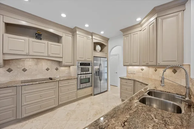 a kitchen with granite countertop a sink stainless steel appliances and cabinets