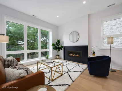 a living room with furniture a large window and a fireplace