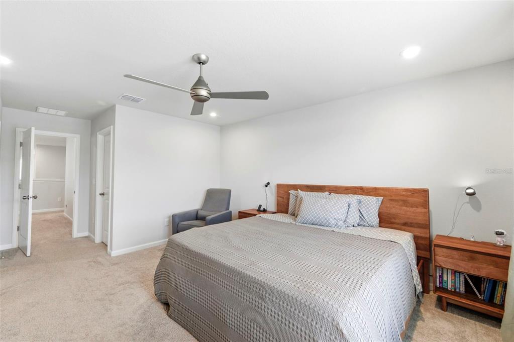 4327 Cloud Hopper Way Lutz, FL 33559 - Photo 31 of 75 a bedroom with a bed and a chandelier