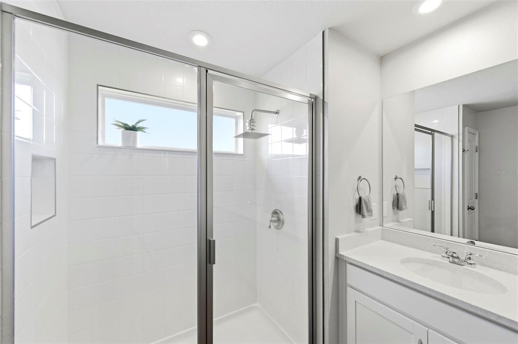 4327 Cloud Hopper Way Lutz, FL 33559 - Photo 33 of 75 a bathroom with a shower sink vanity and mirror