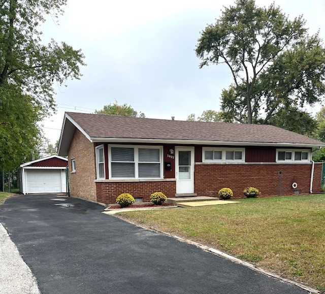 a front view of a house with a yard and a garage