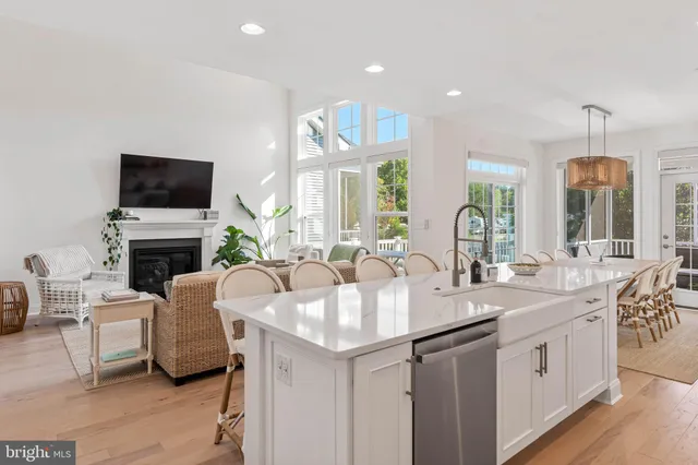 a large white kitchen with a sink and a fireplace