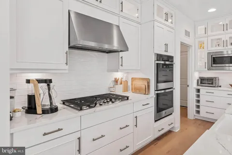 a kitchen with stainless steel appliances granite countertop a sink stove and cabinets