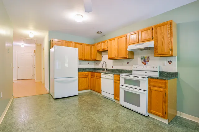 a kitchen with a refrigerator sink and cabinets