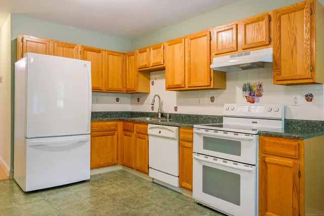 a kitchen with a refrigerator sink and cabinets