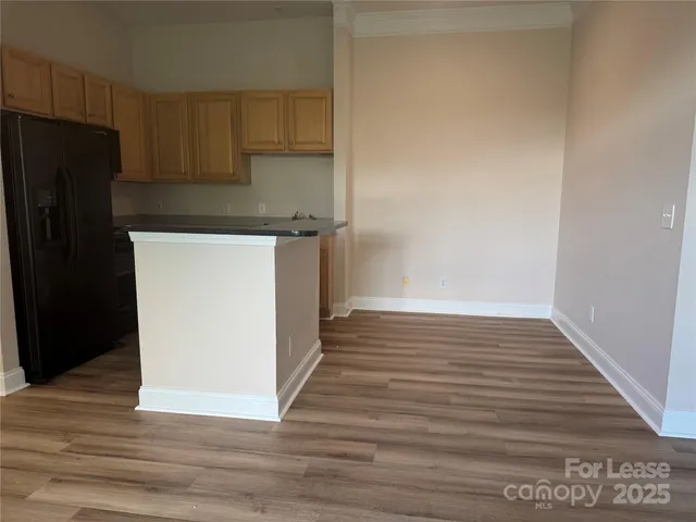 a view of a kitchen with wooden floor and a refrigerator