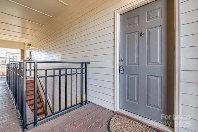 a view of a hallway with wooden floor and stairs