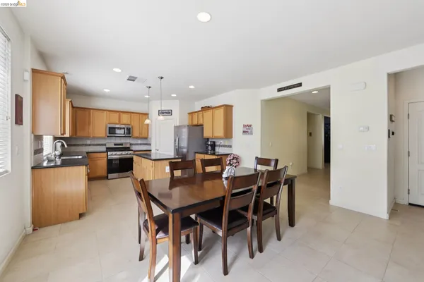 a kitchen with stainless steel appliances granite countertop a sink refrigerator and cabinets