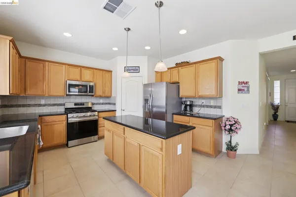 a kitchen with stainless steel appliances granite countertop a stove and a microwave