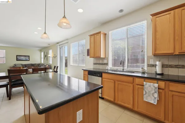 a kitchen with stainless steel appliances granite countertop a sink a counter and chairs