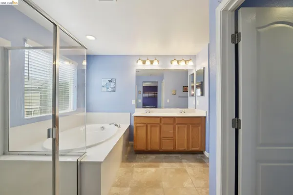 a bathroom with a tub sink and mirror
