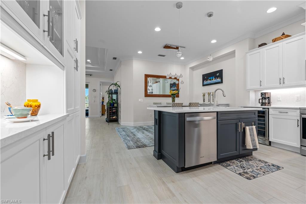 8781 Yucatan Court Naples, FL 34113 - Photo 14 of 36 a kitchen with stainless steel appliances a sink a stove a refrigerator cabinets and living room view
