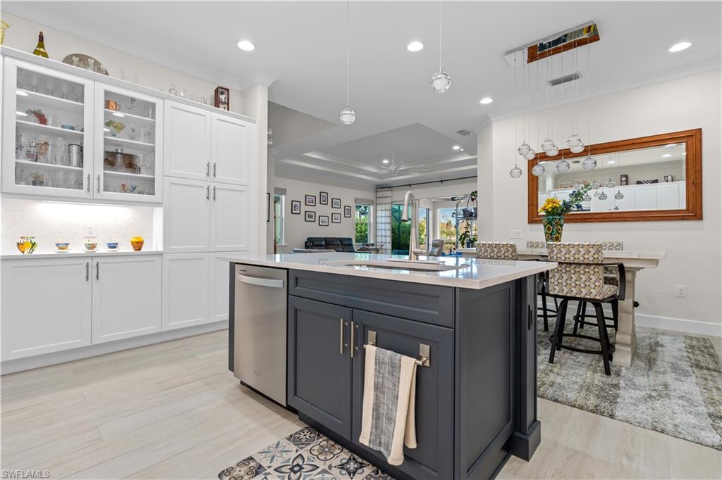 8781 Yucatan Court Naples, FL 34113 - Photo 15 of 36 a kitchen with kitchen island a sink a stove a dining table and chairs