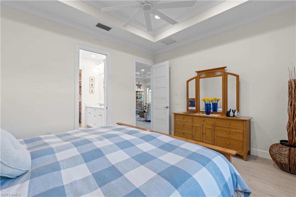 8781 Yucatan Court Naples, FL 34113 - Photo 17 of 36 a bedroom with a bed and a mirror on dresser