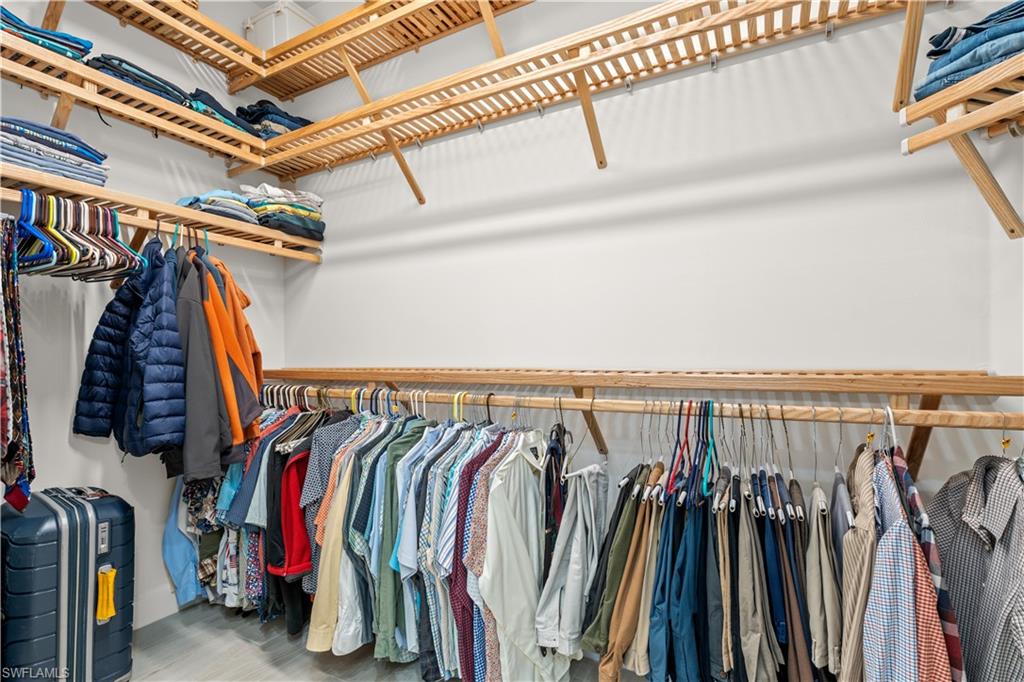 8781 Yucatan Court Naples, FL 34113 - Photo 19 of 36 a view of walk in closet with clothes and shoes
