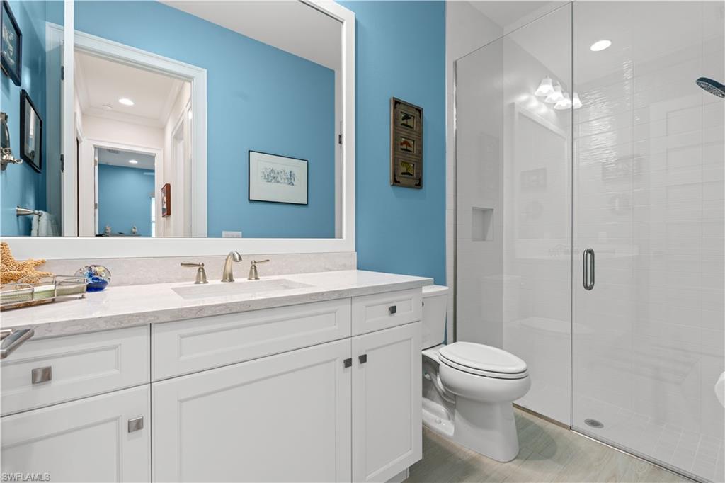 8781 Yucatan Court Naples, FL 34113 - Photo 25 of 36 a bathroom with a toilet sink a mirror and shower