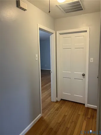 an empty room with wooden floor and closet