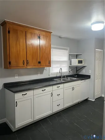 a kitchen with granite countertop white cabinets and a sink
