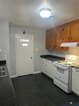 a kitchen with granite countertop a sink cabinets and stainless steel appliances